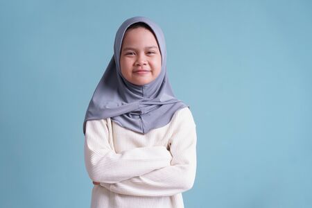 Portrait of Happy Muslim little girl smile and looking to camera on blue background  isolatedの写真素材