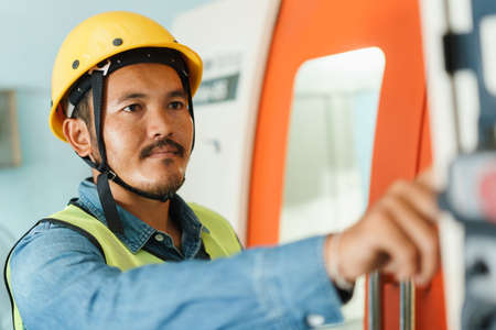 Close up of face worker on machine control panel display in the factoryの写真素材