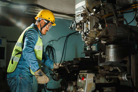worker Drilling machine hole metal flat steel plate and selective focus with bench drill in the factoryの写真素材