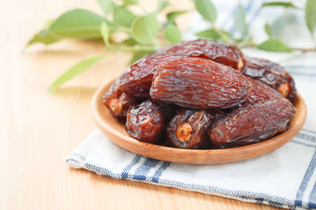 Date fruit in wood bowl on placemat