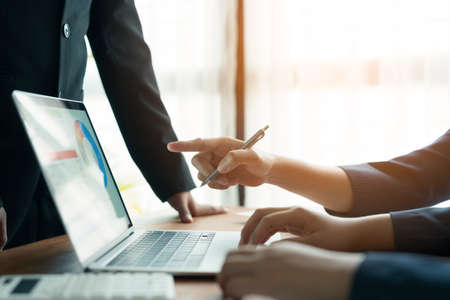 Business people discussing meeting and graphs showing the results on a computer laptop, Close- up of...