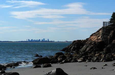 view of the boston skyline from the shore of the atlantic ocean in gloucester massachusettsの写真素材