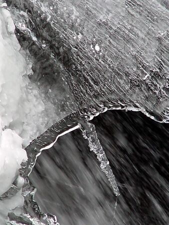 large section of snow and ice above  flowing water