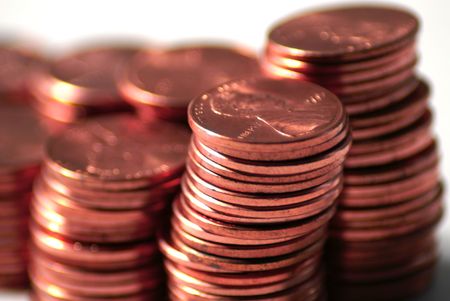 close up of stacks of pennies against a white background