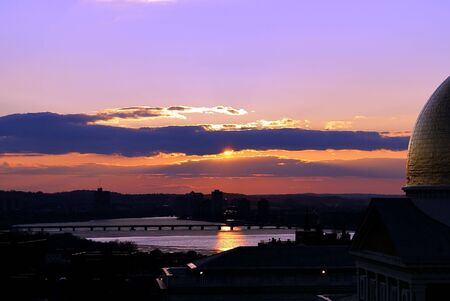 Vivid colorful sunset over the charles river in boston massachusetts with the golden dome of the state houseの写真素材