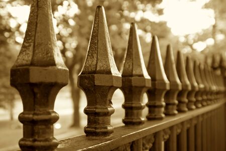 sepia toned image of wrought iron fence trailing off into the distanceの写真素材