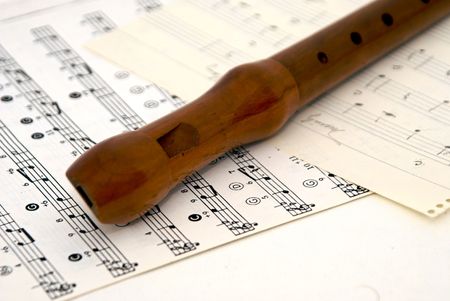 woodwind recorder laying diagonally on sheet musicの写真素材