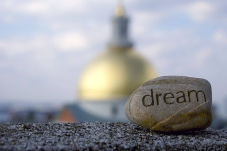 dream rock sits on cement ledge with the massachusetts state house in the background,representing dreams of success and achievementの写真素材
