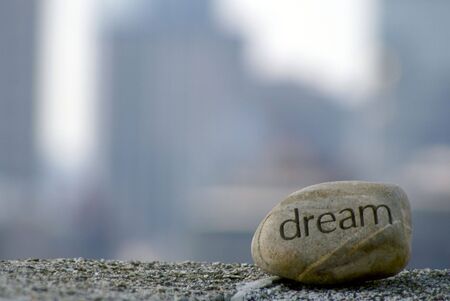 dream rock sits on cement ledge with the boston skyline in the background,representing dreams of successの写真素材