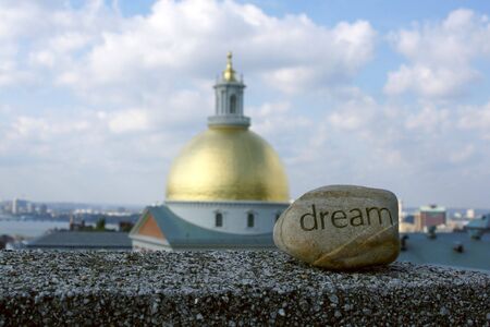 dream rock sits on cement ledge with the massachusetts state house in the background,representing dreams of success and achievementの写真素材