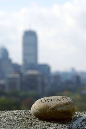 dream rock sits on cement ledge with the boston skyline in the background,representing dreams of successの写真素材