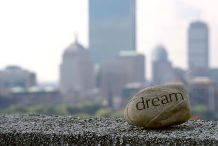 dream rock sits on cement ledge with the boston skyline in the background,representing dreams of successの写真素材