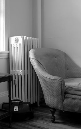 old living room showing steam radiator, chaise lounge sofa, end table and black leather doctor bagの写真素材