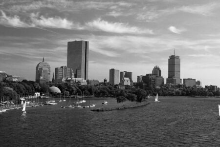 beautiful view of the boston skyline from across the charles river, the water is choppy and there are sailboats in the waterの写真素材