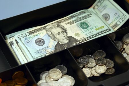 cash box full of money, bills and coinsの写真素材