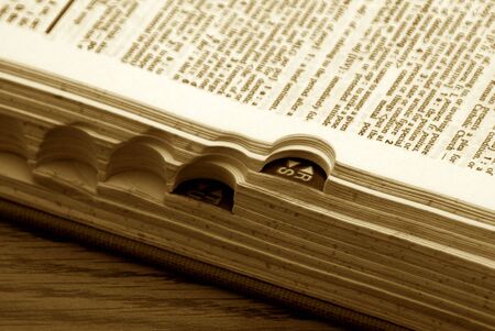 old dictionary with page open, showing side tabs in sepiaの写真素材