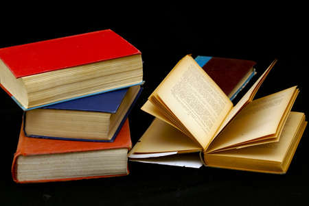 table full of old books, one with yellowed pages showing