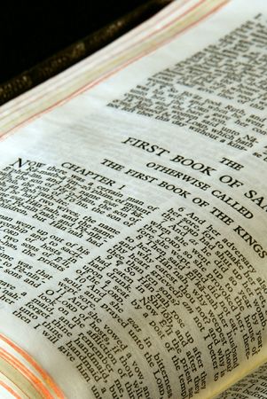 bible series, detail of an old antique holy bible against a black background open to the first book of samuel otherwise called the first book of the kingsの写真素材