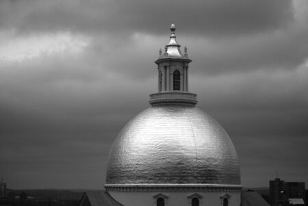 glowing black and white image of the golden dome of the massachusetts state house in boston at early...