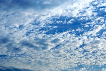 fast moving clouds flying across a light blue skyの写真素材
