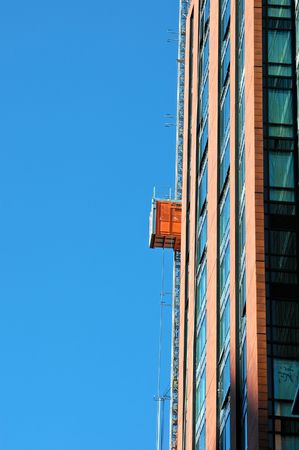 construction elevator rising and lifting people to work on new buildingの写真素材