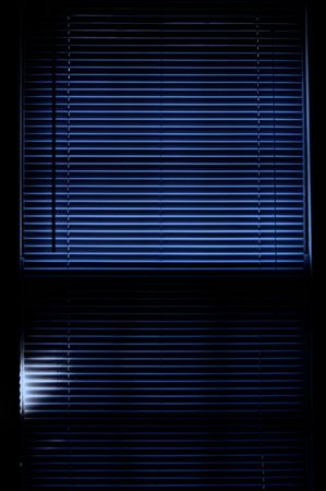 deep rich blue image of mini blinds covering windowの写真素材
