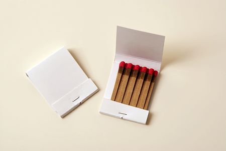 two white blank matchbooks showing front and an open book on cream colored background suitable for...