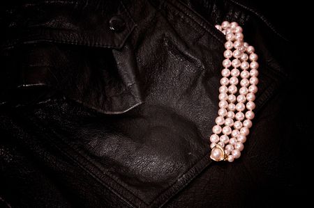 four strands of pearls coming out of pocket of black leather jacket with gold and diamondsの写真素材