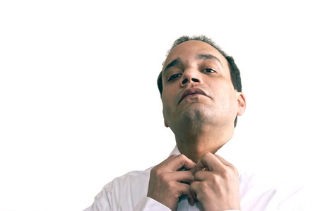 african american male wearing white dress shirt against white background with head tilted back fixing collarの写真素材