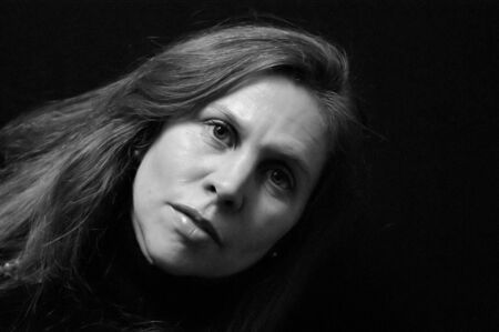portrait of pretty serious looking woman with long hair in black and white . side lighting