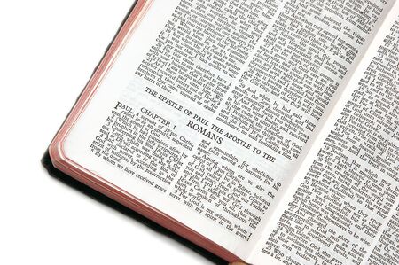holy bible open to the epistle of paul the apostle to the romans, against a white backgroundの写真素材