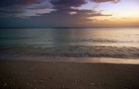 the sea flows in and out with the movement captured here at sunsetの写真素材