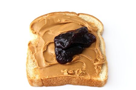 slice of white bread with peanut butter and grape jam on white.