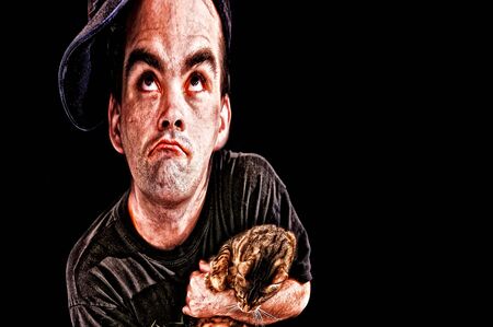 in this distorted illustration a man with big eyes is looking up as if he did something wrong, holding catの写真素材