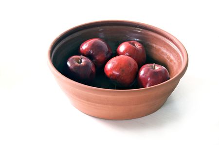 a ceramic terra cotta bowl filled with five red apples. on whiteの写真素材