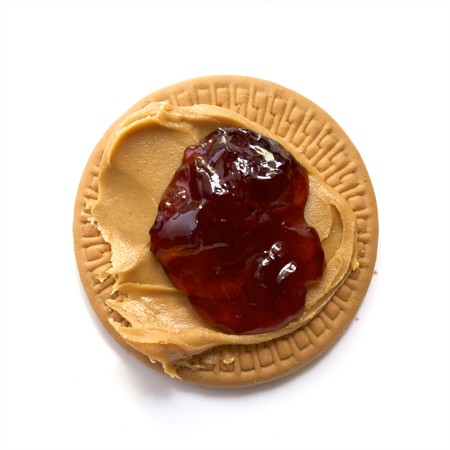creamy peanut butter  and strawberry jam spread on round shortbread cookieの写真素材