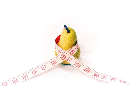 A tall slender pear with measuring tape wrapped around it showing fruit is good for weight loss.の写真素材