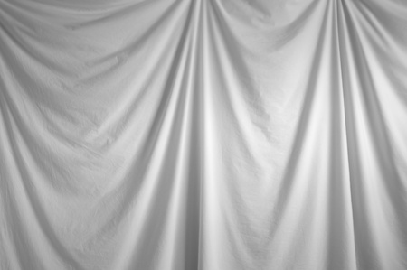 a white fabric draped backdrop hanging indoors.の写真素材