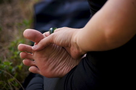a woman is sitting in lotus position holding her foot with her hand