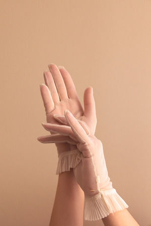 Image of woman's forearms and hands modeling vintage sheer see through gloves.の写真素材