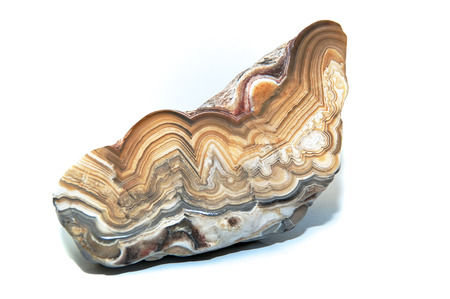 A layers and colorful cut and polished stone over white showing the various designs within. Over...
