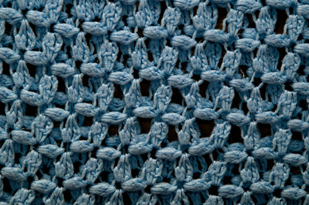 A large blue crocheted afghan blanket fills the frame of this image making it suitable for knitting background.の写真素材