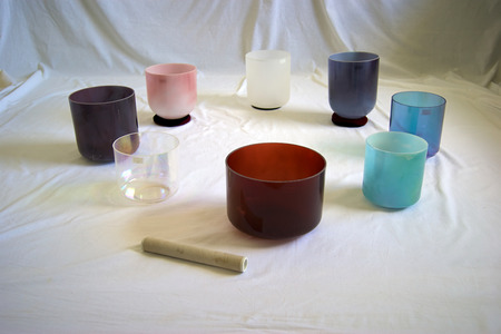 A collection of colorful crystal singing bowls against white backdrop.の写真素材