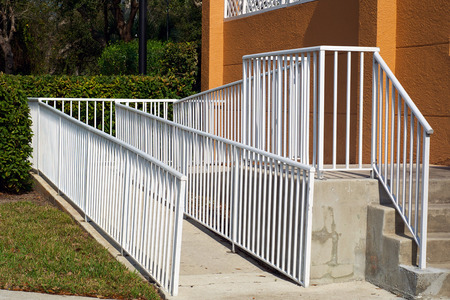 A white metal railing encloses a handicap ramp leading up to a building in Naples, Florida.の写真素材