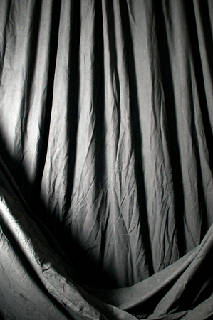 Vertical image of draped black theatrical curtain or backdrop.の写真素材