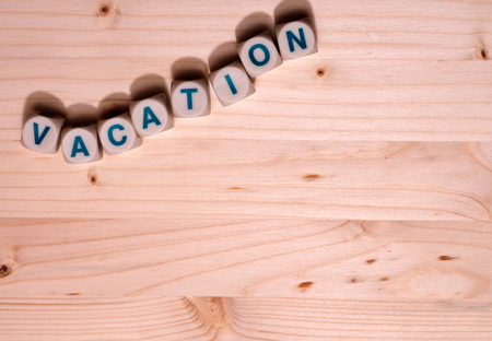 Blank light colored wood fills this template image with the word Vacation spelled out in blocks along the top.の写真素材