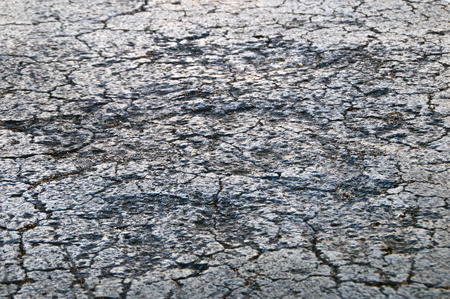 Low angle close up view of cracked and damaged roadway tar asphalt.の写真素材