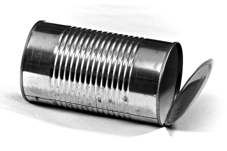 A large empty food tin can has been opened and is laying down, photographed on white,  used for...