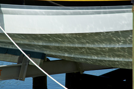 Semi abstract image of water reflection on hull of boat at marina, with copy space.の写真素材