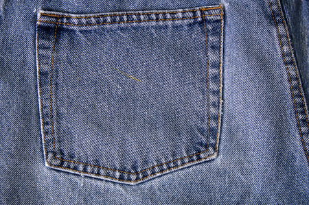 close up of back pocket on pair of old faded blue jean denim.の写真素材